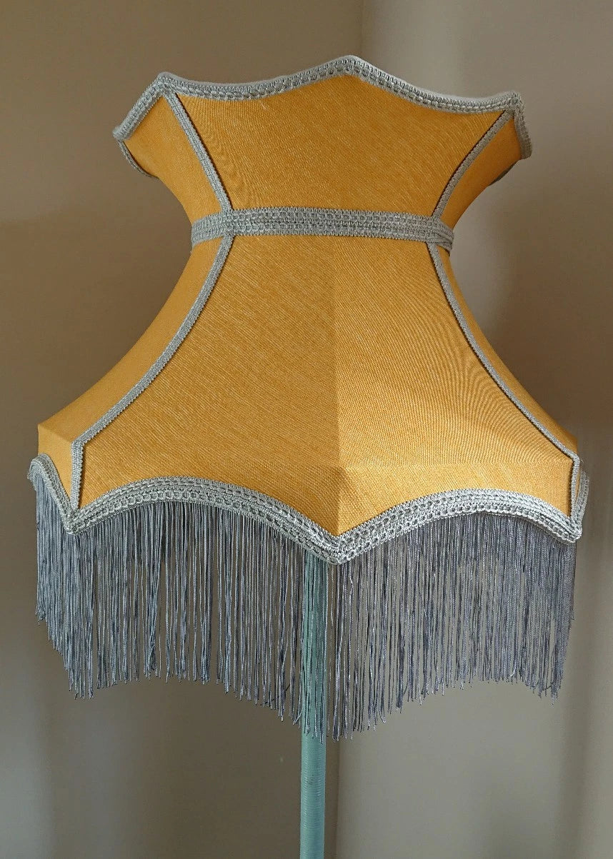 Lampshade in mustard yellow fabric in crown shape with grey trim and lining