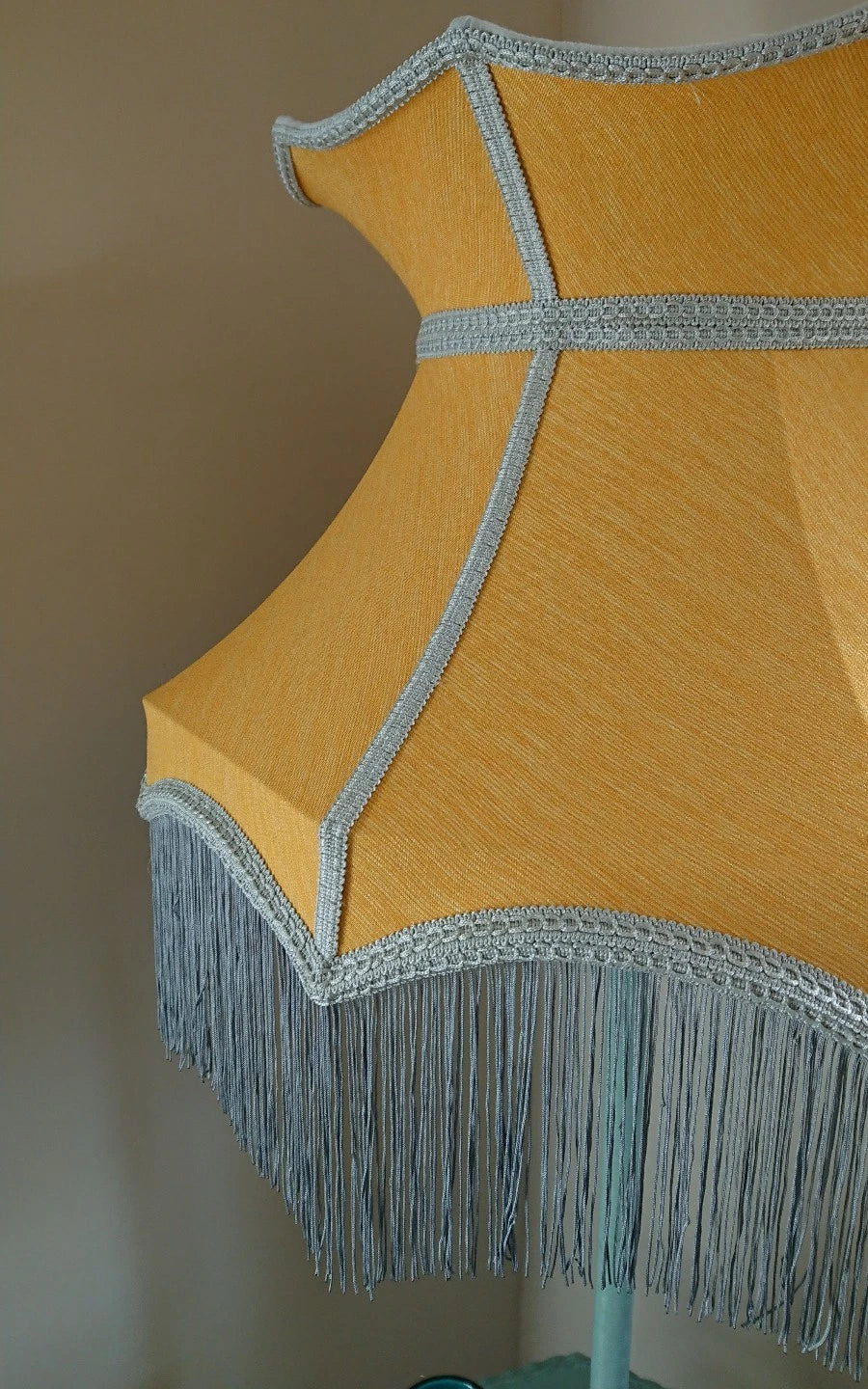 Lampshade in mustard yellow fabric in crown shape with grey trim and lining